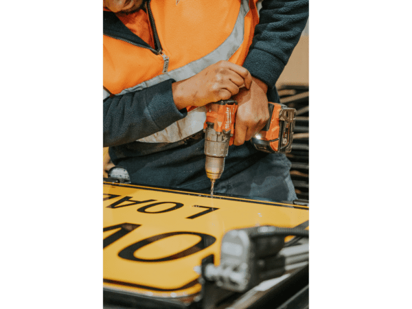 drilling holes into the frame for the sign